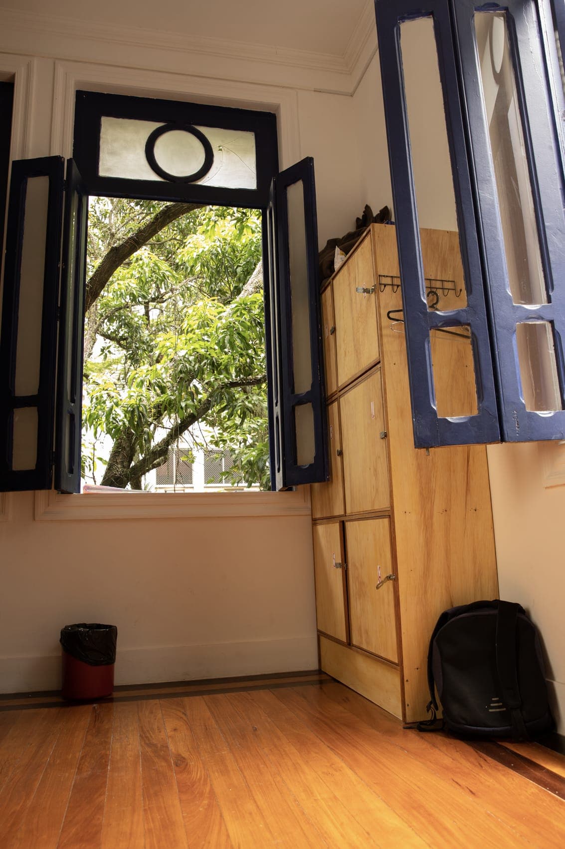 Wooden lockers and a shuttered window in the women-only dorm